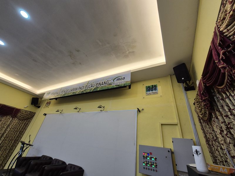 Seminar hall at IADA Pulau Pinang with the projection screen and wall-mounted loudspeakers either side