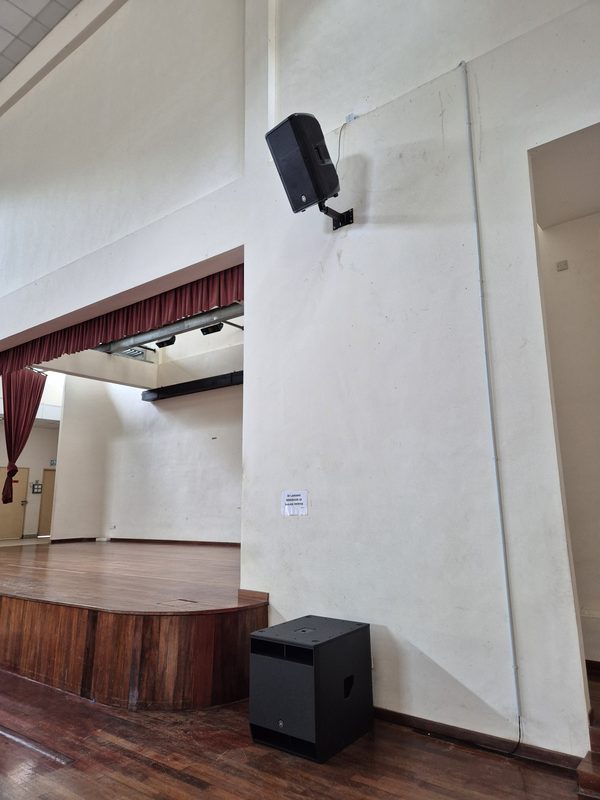 Loudspeakers mounted at high level on the hall wall for even coverage