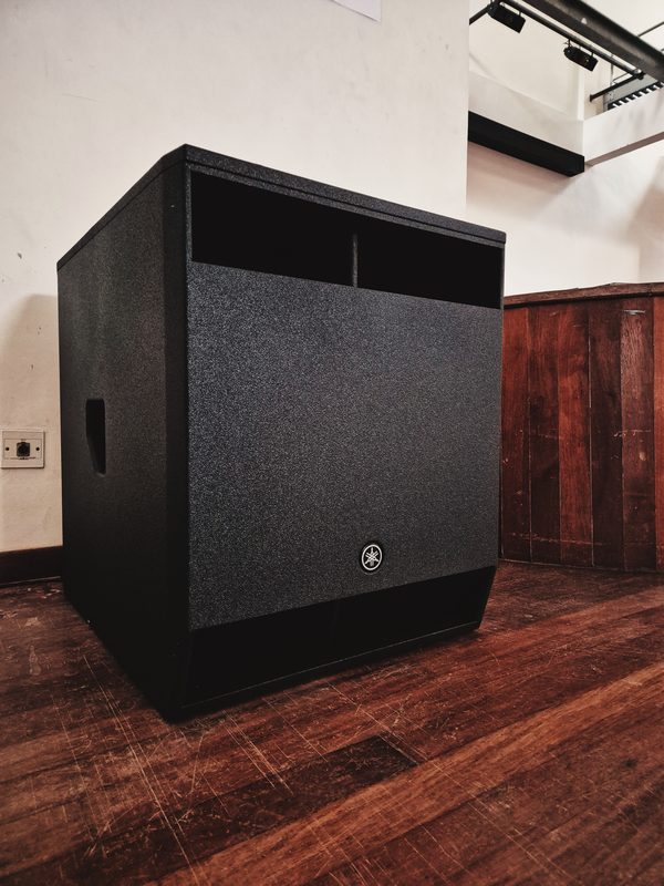 Yamaha subwoofer positioned on the hall floor beside the stage