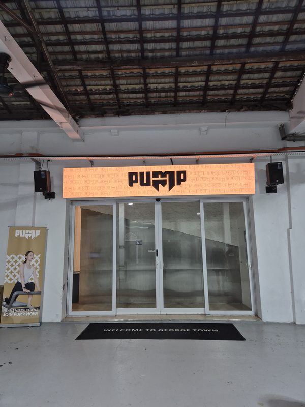 Entrance to the Pump gym with loudspeakers mounted either side of the signage