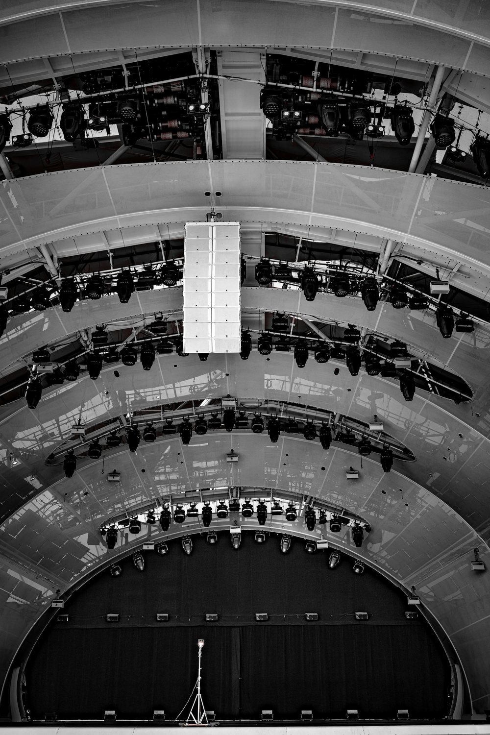 Auditorium interior with a flown loudspeaker array and overhead lighting rig