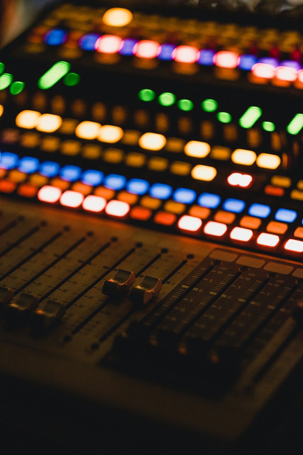 Close-up of the illuminated channel strips on a digital mixing console