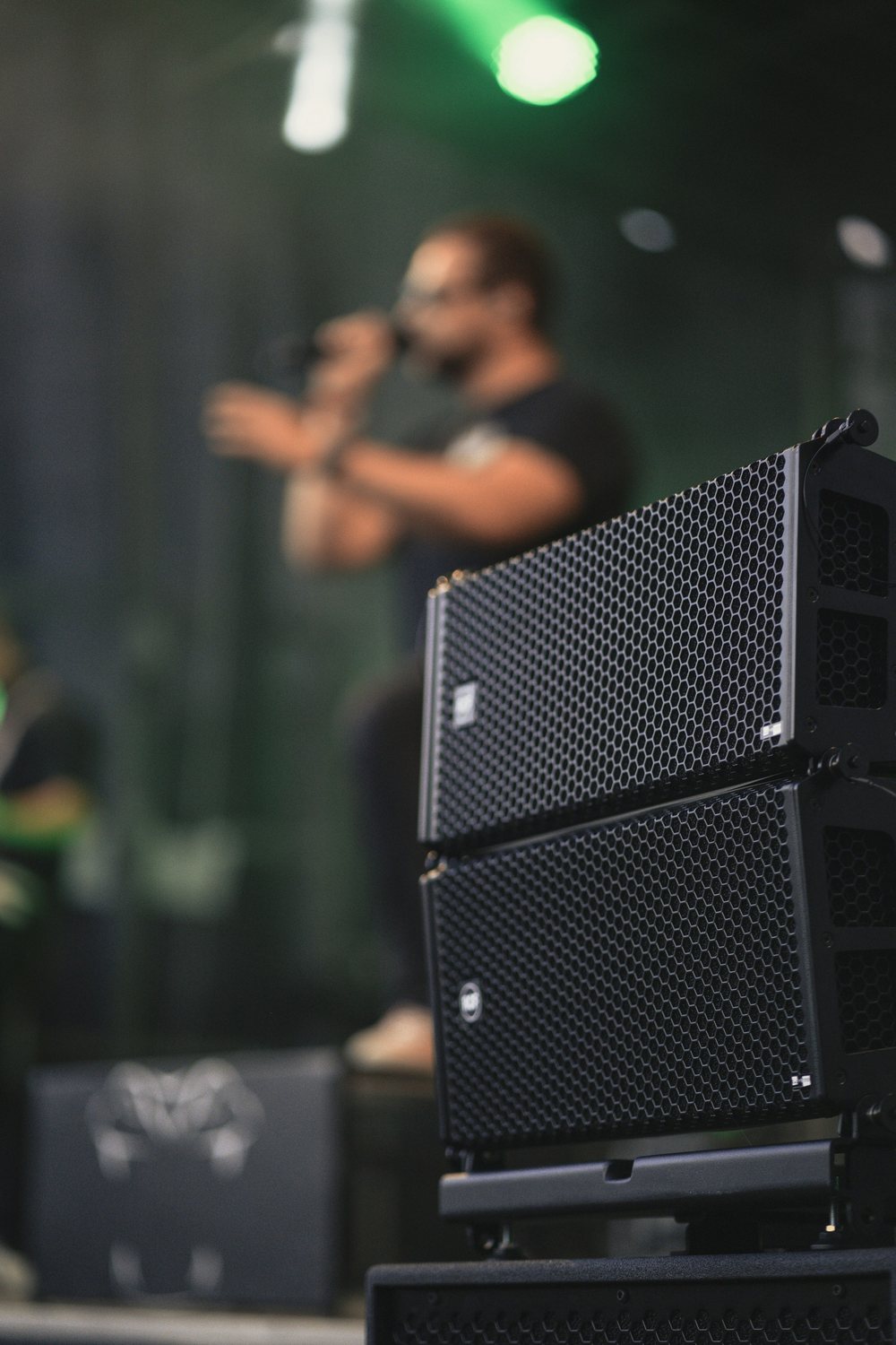 Professional PA loudspeakers set up at the side of a stage during a live event